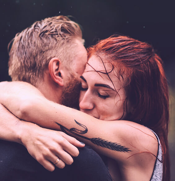 two sad people hugging each other in rain
