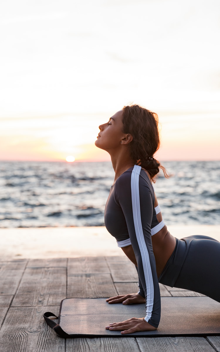 woman in the beach doing stretching exercises