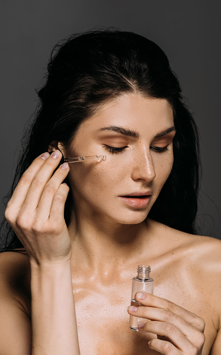 woman using serum for agging skin on face