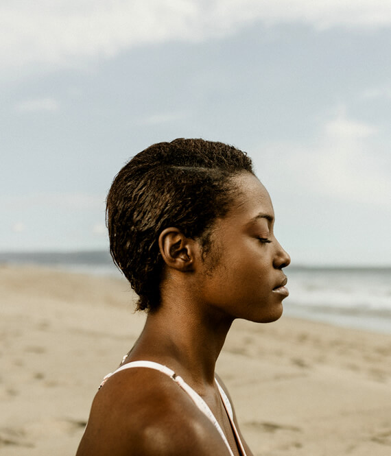 woman meditating on the beach
