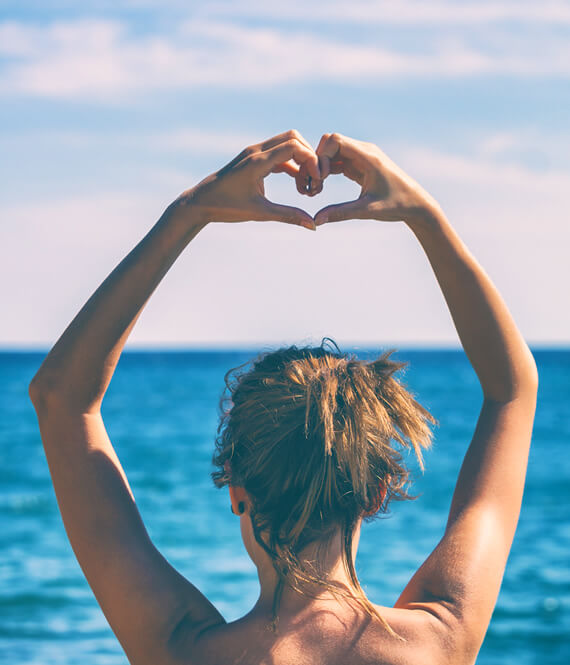 woman doing heart shape with hands as symbol of learning to love yourself