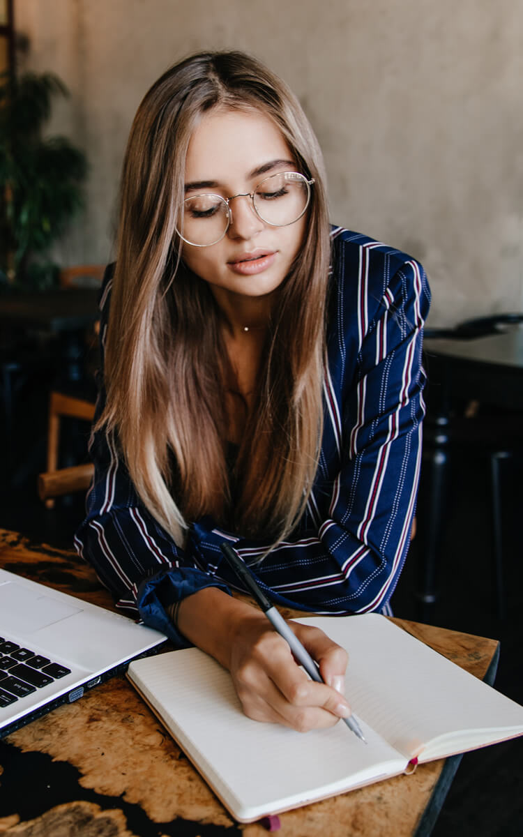 woman writing her 10 year plan in pretty notebook