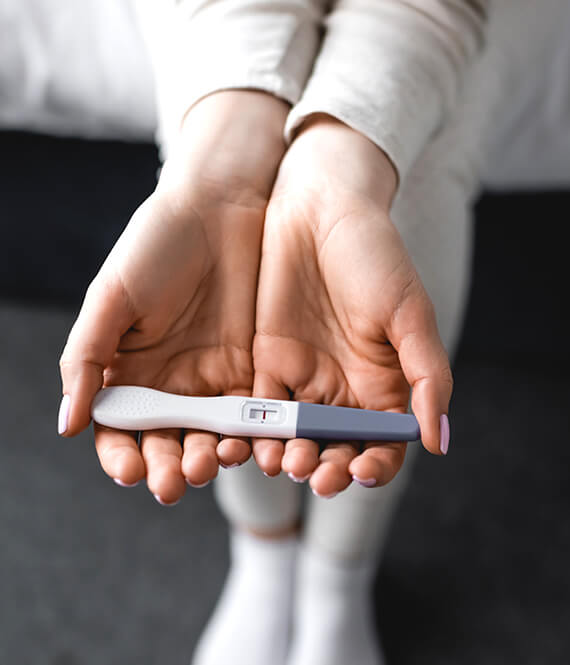 sad woman holding a negative pregnancy test
