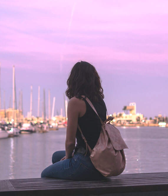 pretty woman on a self journey sitting in a harbor