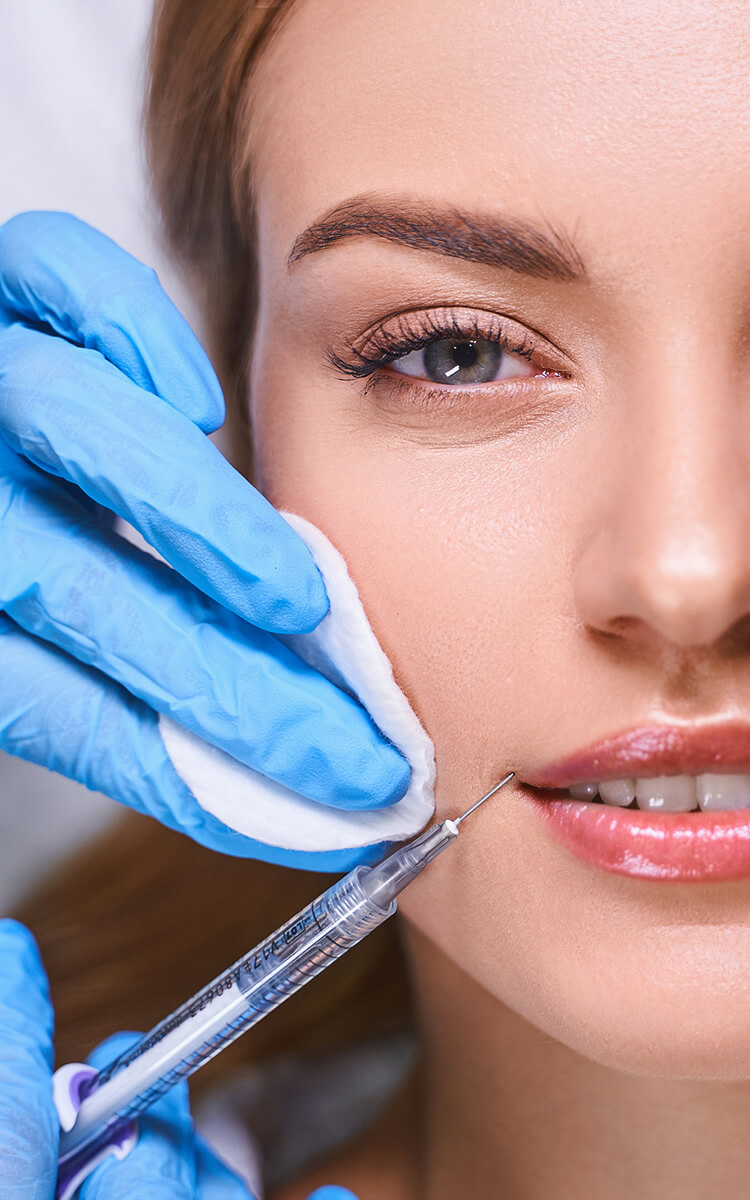 an estheatician injecting botox into womans face