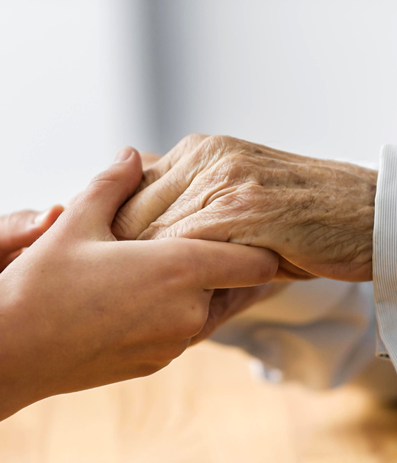 woman holding hands of a senior who has dementia in elderly
