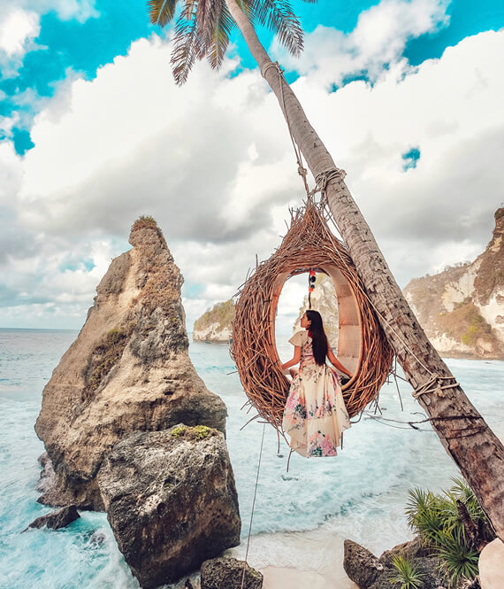 woman on a palm tree swing