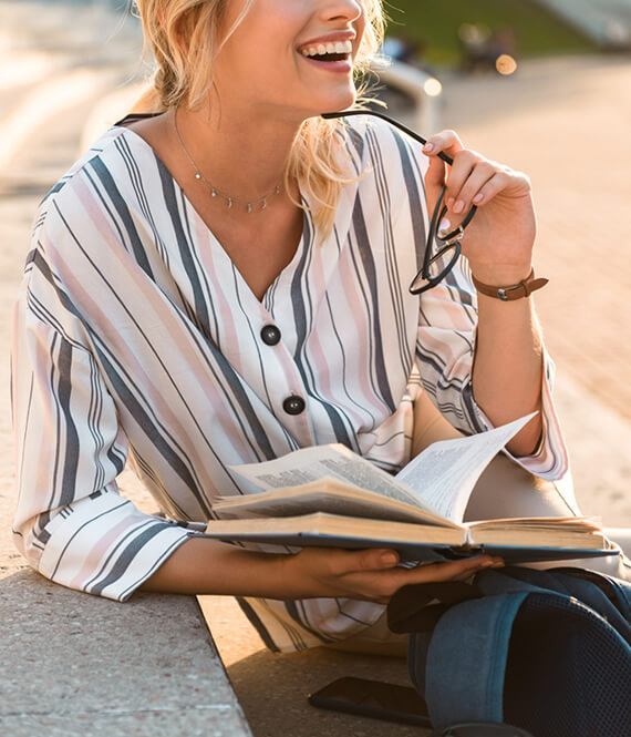 healthy college student smiling while reading