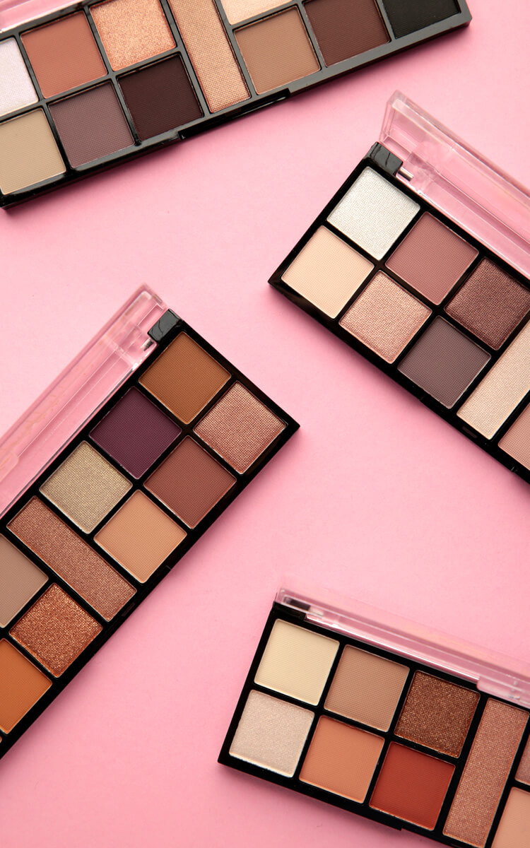 makeup palettes on a pink table