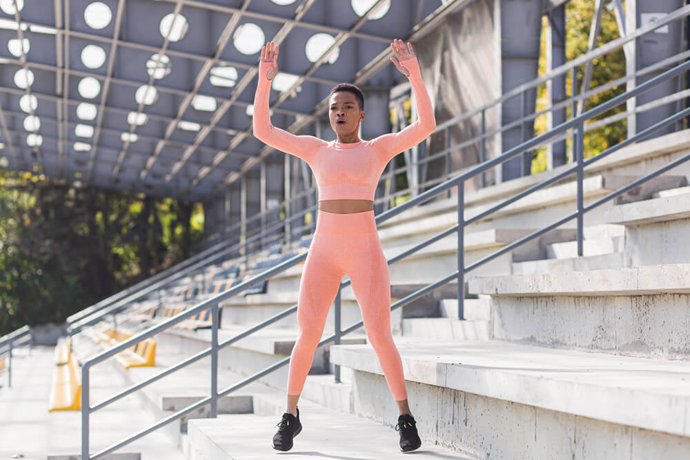 woman showing how to do burpees with proper form
