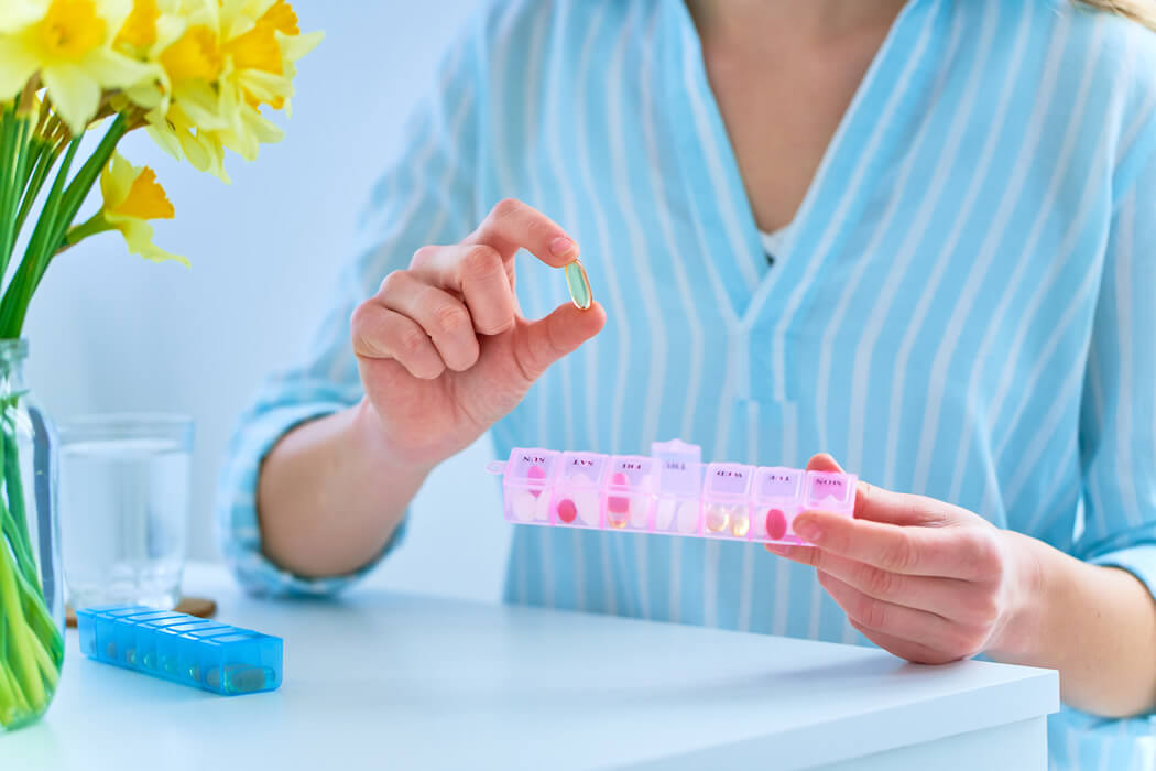 woman using a pill box to organize meds for a week