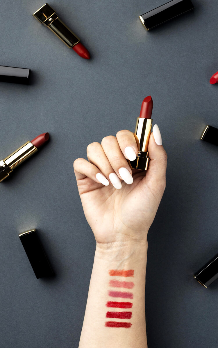 woman with lipstick swatches on her arm