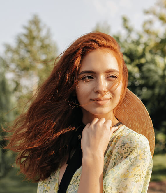 woman with red hair and blow out after summer hair care routine