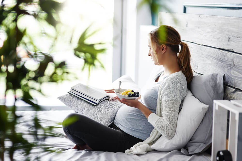 pregnant woman eating fruit salad