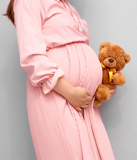 pregnant woman with a teddy bear