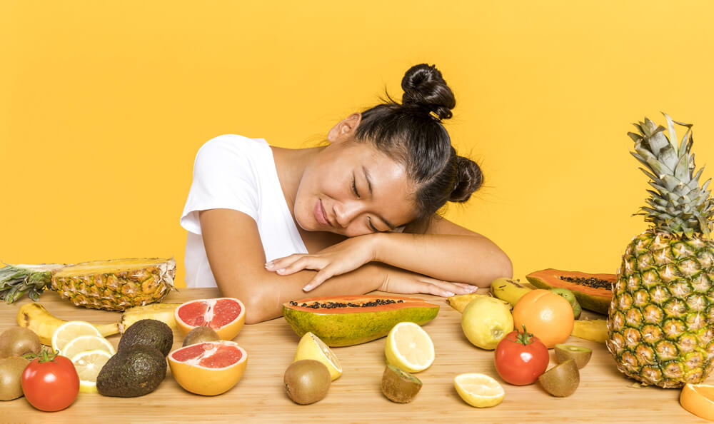 woman surrounded with enzyme-rich fruits