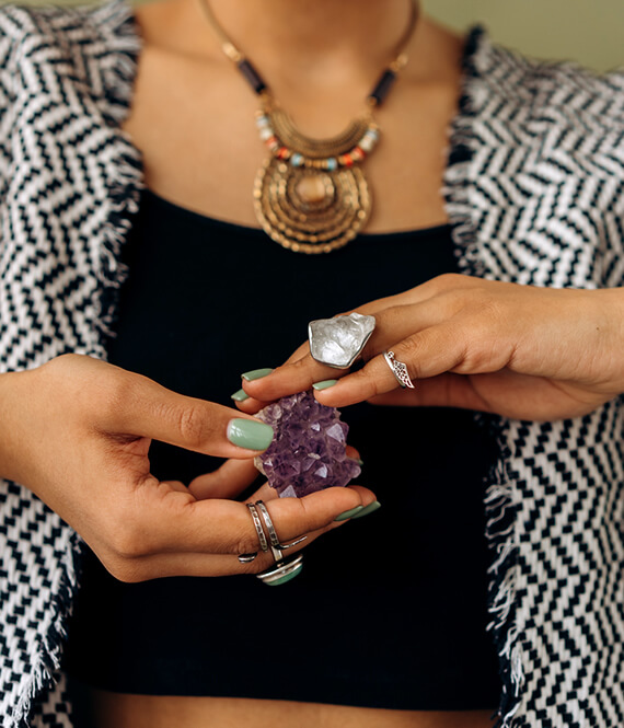woman holding amethyst - one of the believed healing crystals - in her hands