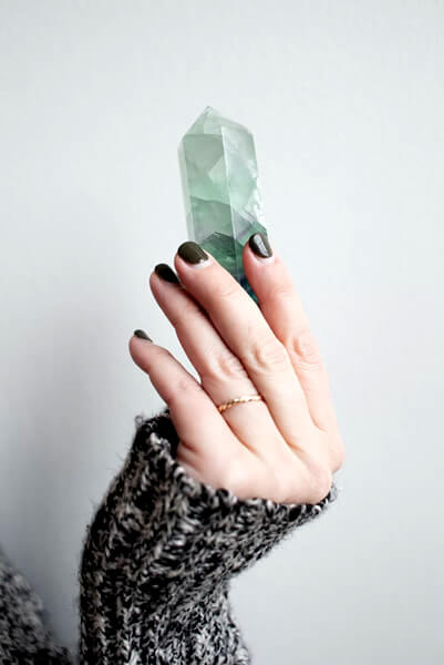 woman holding green quartz crystal