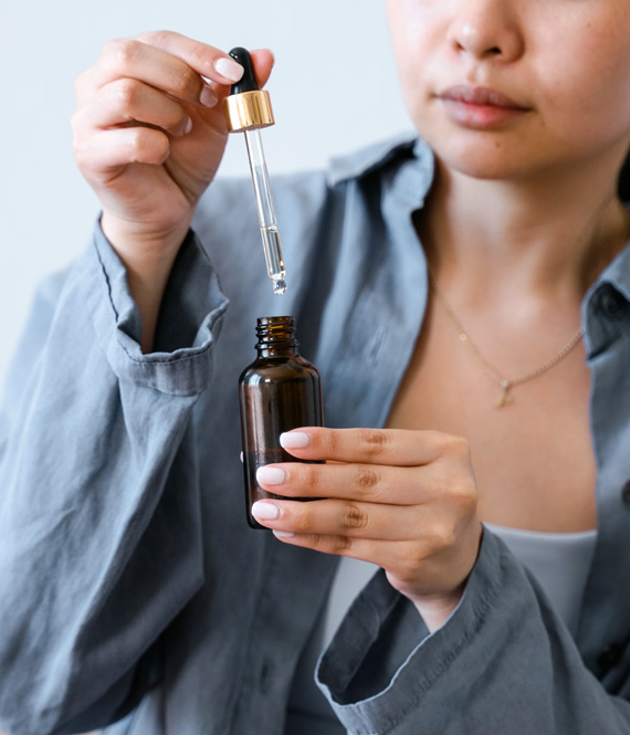 holding a dropper bottle of azelaic acid