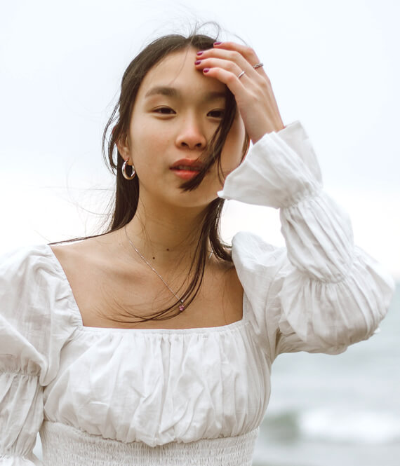 oriental woman touching acne-free forehead