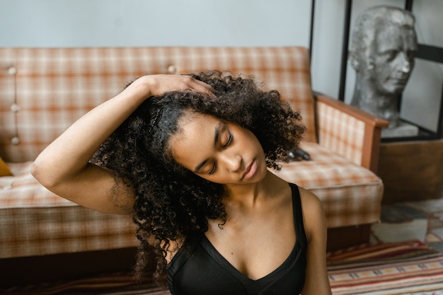 woman sitting on the floor, mindfully stretching in her living room