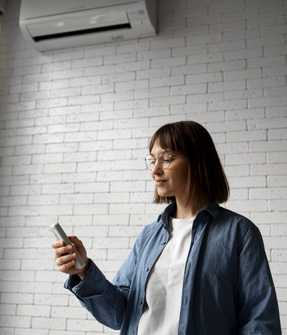 woman using air conditioner unit at home