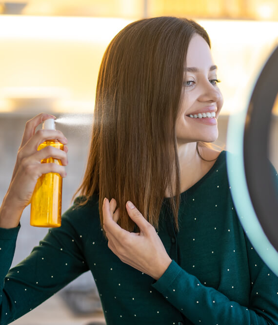 applying heat protectant spray to hair