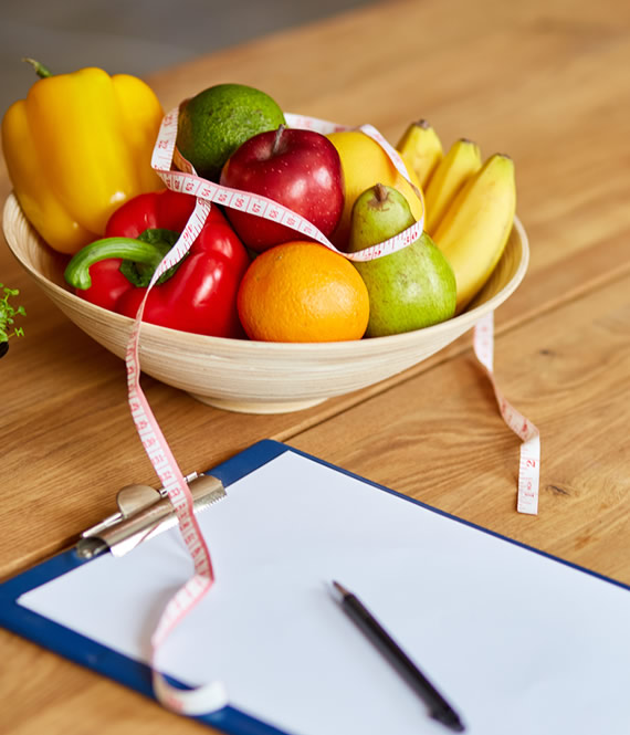 weight program sheet on table with fruits and veggies