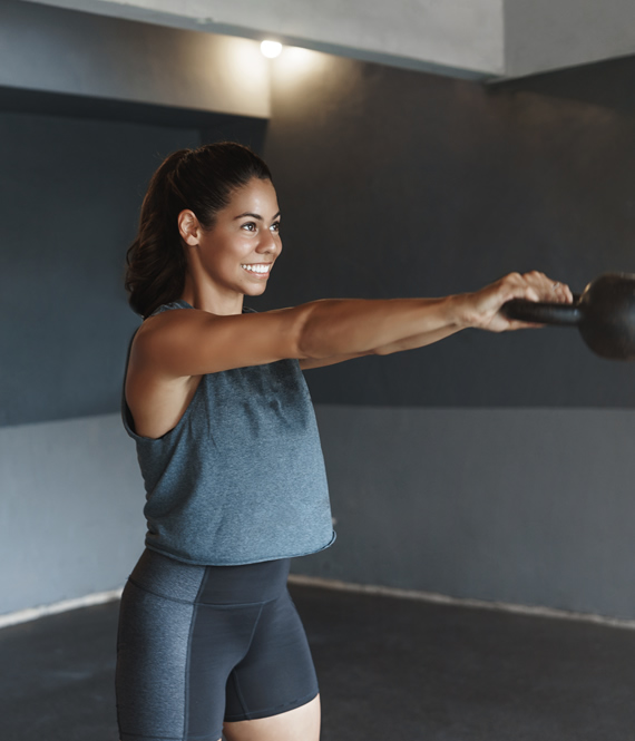 strong hispanic sportswoman doing a kettle bell workout