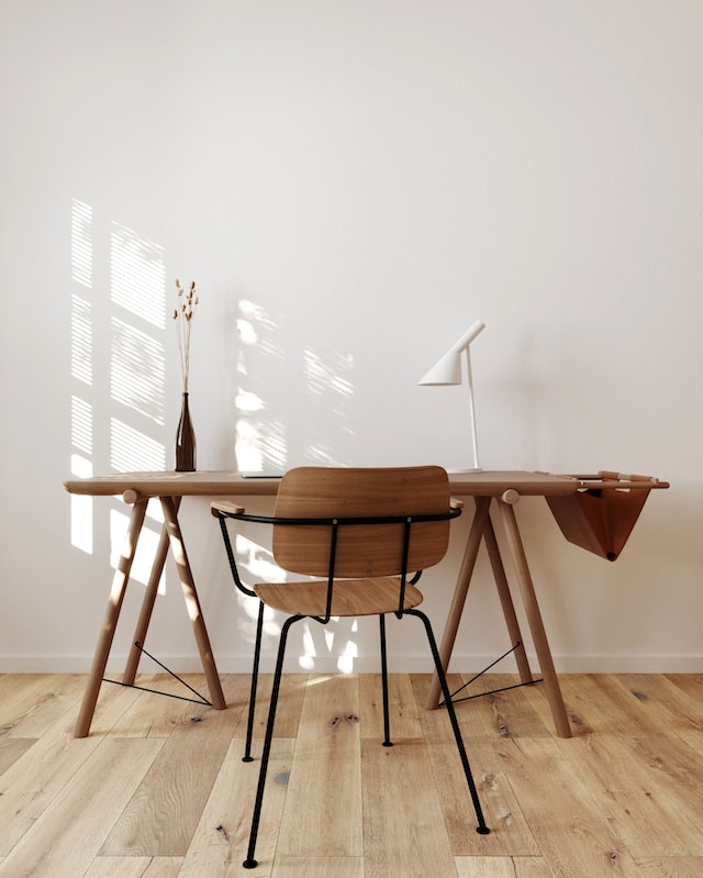 scandi style office space, a wooden desk with a wooden chair, with a vase and a lamp on top of the desk, clutter free space