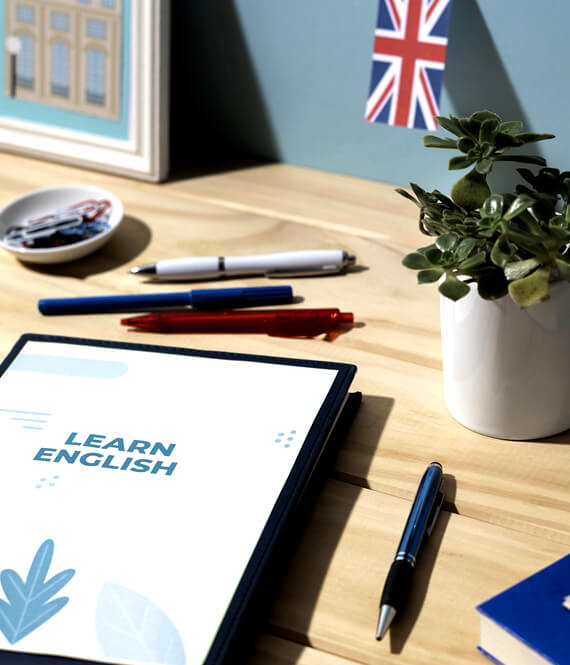 english language course on a tablet next to pencils and english flag