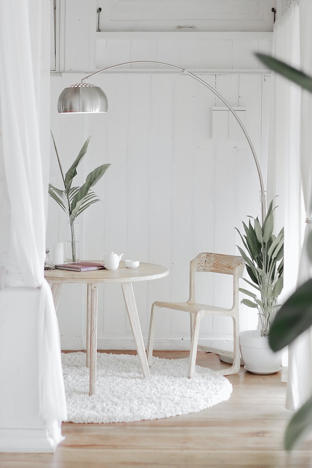 scandi style living space with light wood table and chair, with tea on the table, surrounded by plants
