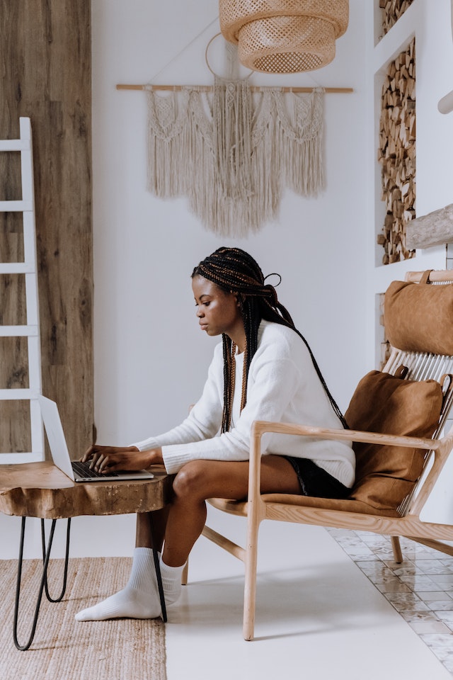 woman working on her laptop, sitting in a scandi style space