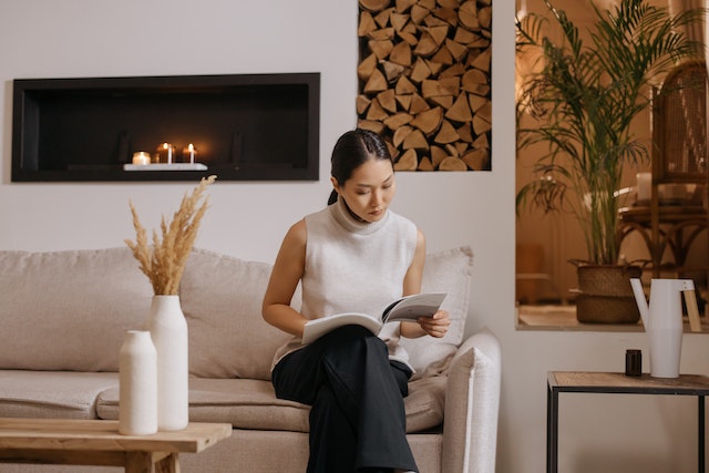 woman reading a book, sitting in a scandi style living room