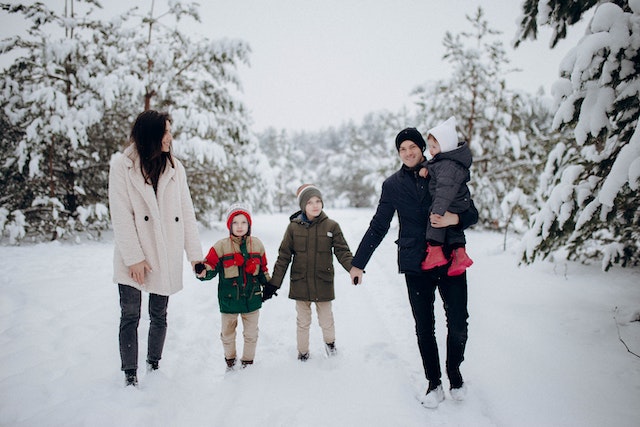family with three kids taking a nature walk in the forest 