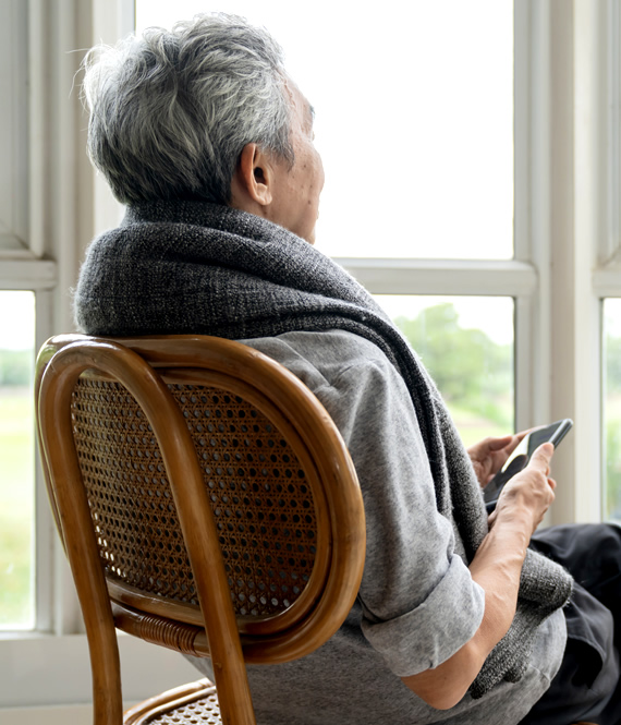 depression in elderly example - depressed senior person looking through the window with sadness