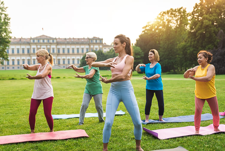 multiethnic group of people practising qi gong in the field