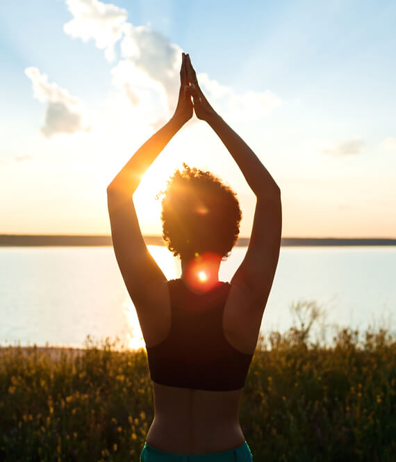 woman practicing quick self care yoga in the morning sun