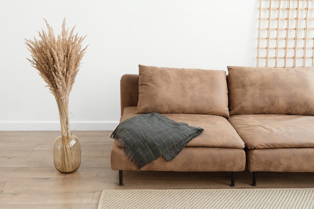 a brown sofa in a living room standing across a white wall