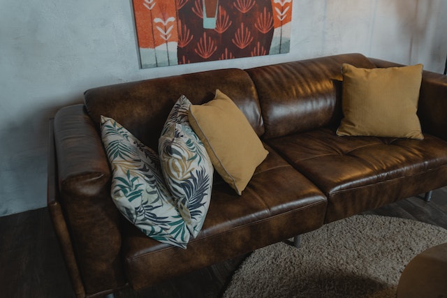a brown sofa in a living room with colorful pillows