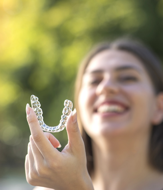 woman holding invisalign braces