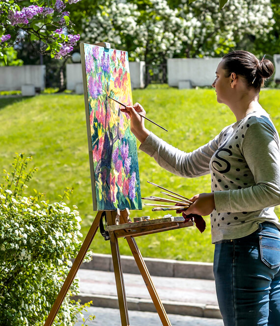 artist painting an oil painting in nature