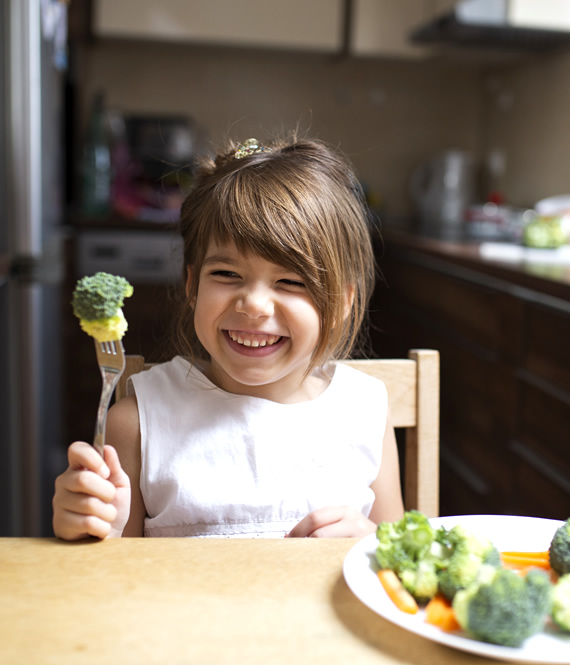 happy child eating broccoli