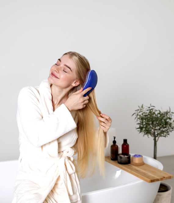 smiling woman brushes her soft and healthy hair