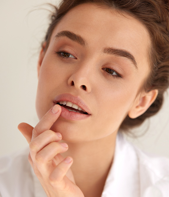 woman checking her lips after microneedling for lips procedure