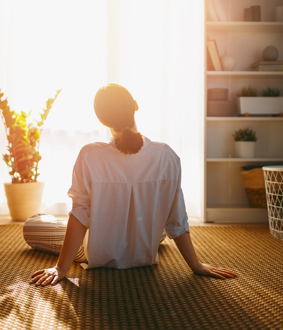 woman enjoys natural sunlight shining through room windows