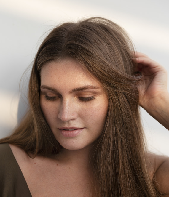 woman touching her hair experiencing hair loss