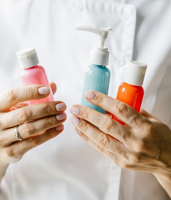 person holds cosmetic bottles