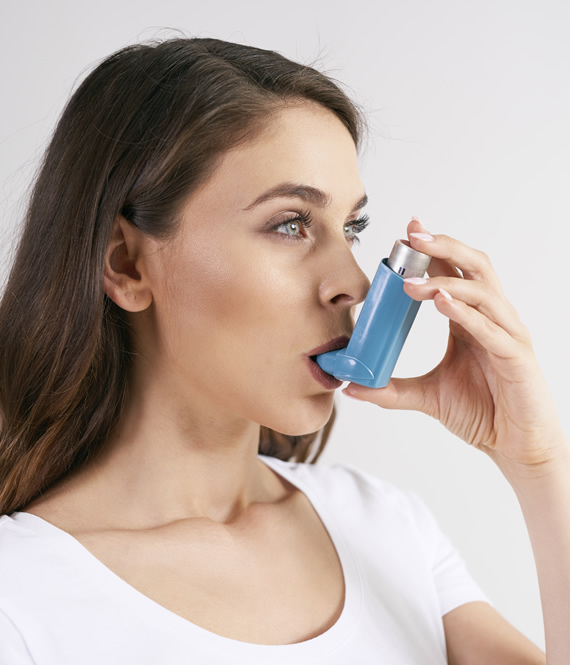 woman uses an inhaler for asthma